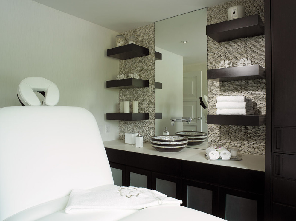 Immagine di un bagno di servizio classico di medie dimensioni con ante lisce, ante nere, piastrelle beige, piastrelle di ciottoli, pareti beige, lavabo a bacinella, top in superficie solida e top bianco
