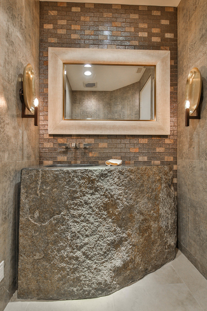 Inredning av ett rustikt mellanstort toalett, med ett integrerad handfat, grått golv, beige kakel, keramikplattor, beige väggar, cementgolv och bänkskiva i kalksten