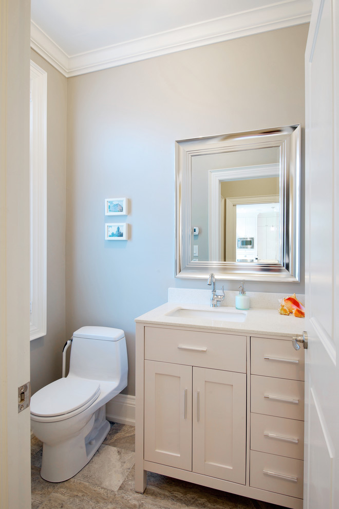 Photo of a medium sized traditional cloakroom in Toronto with a submerged sink, shaker cabinets, white cabinets, engineered stone worktops, a one-piece toilet, grey walls, limestone flooring and beige tiles.