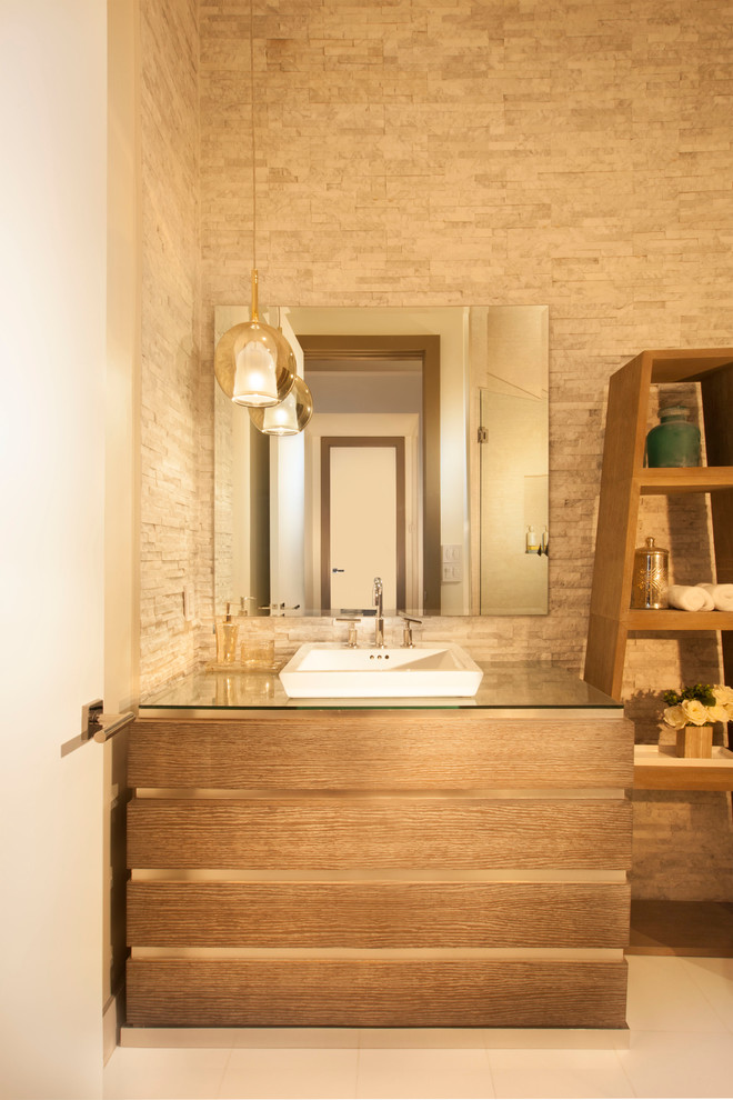 Foto på ett funkis toalett, med ett fristående handfat, släta luckor, skåp i mellenmörkt trä, bänkskiva i glas och beige kakel