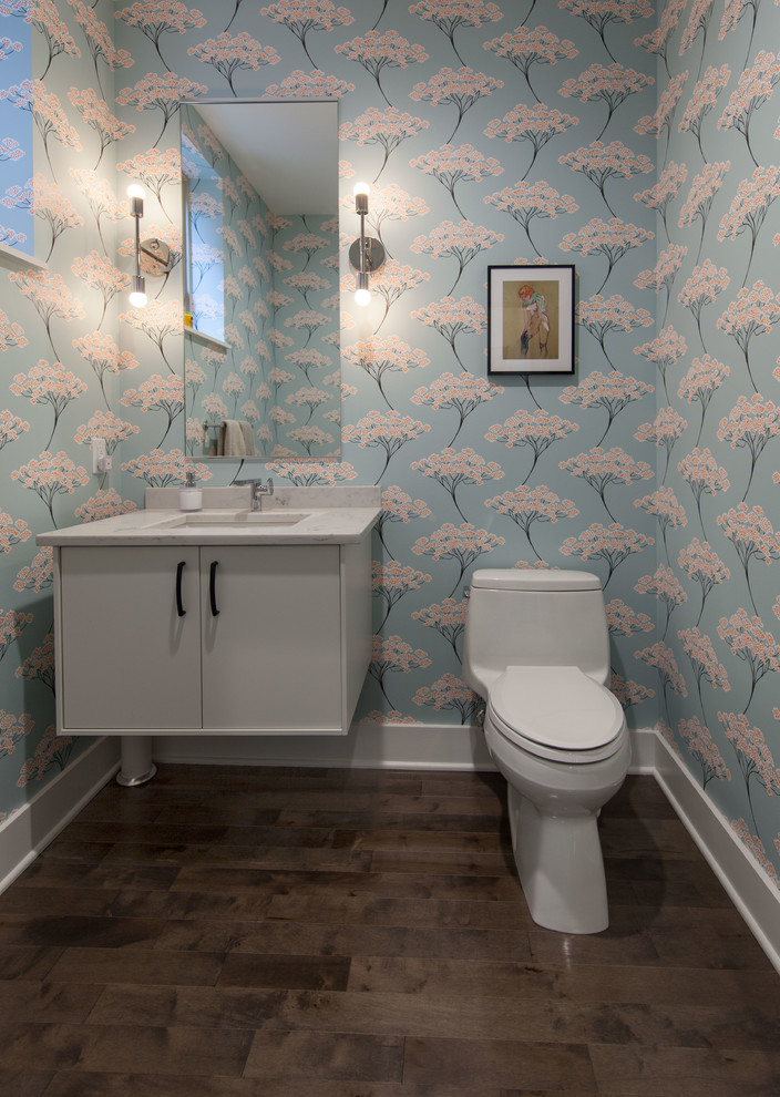 Inspiration pour un petit WC et toilettes traditionnel avec un placard à porte plane, des portes de placard blanches, WC à poser, un mur bleu, un sol en bois brun, un lavabo encastré, un plan de toilette en quartz et un plan de toilette blanc.