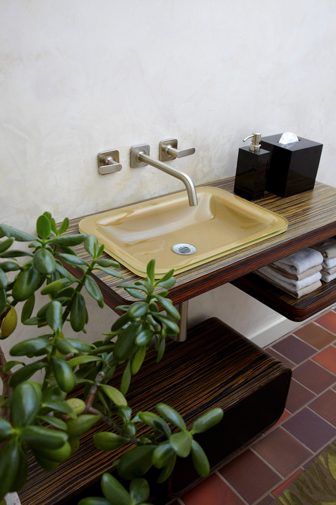 Réalisation d'un WC et toilettes minimaliste en bois foncé avec un placard sans porte, un mur blanc, un sol en carrelage de céramique, un lavabo posé, un plan de toilette en bois et un plan de toilette marron.