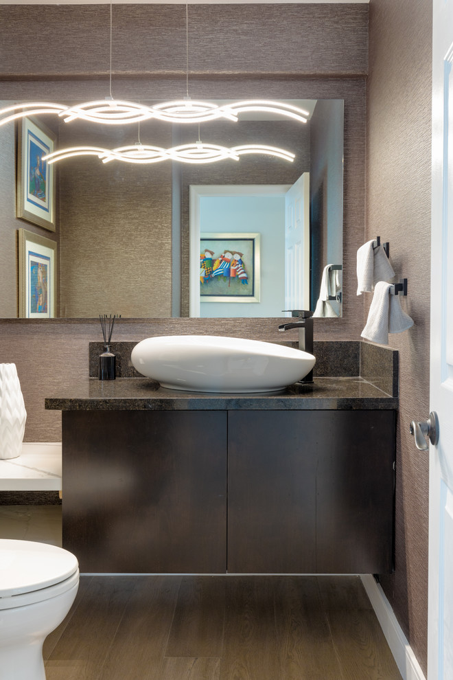 Mittelgroße Moderne Gästetoilette mit flächenbündigen Schrankfronten, brauner Waschtischplatte, braunen Schränken, brauner Wandfarbe, Aufsatzwaschbecken, braunem Boden und dunklem Holzboden in Orange County