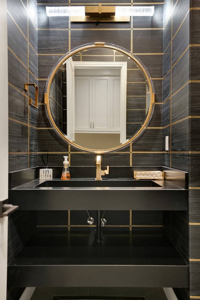 Transitional black tile powder room photo in Orange County with an integrated sink and black countertops