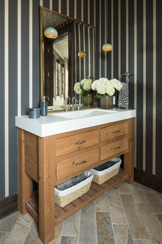 Foto di un bagno di servizio classico con lavabo integrato, ante lisce, ante in legno scuro e top bianco