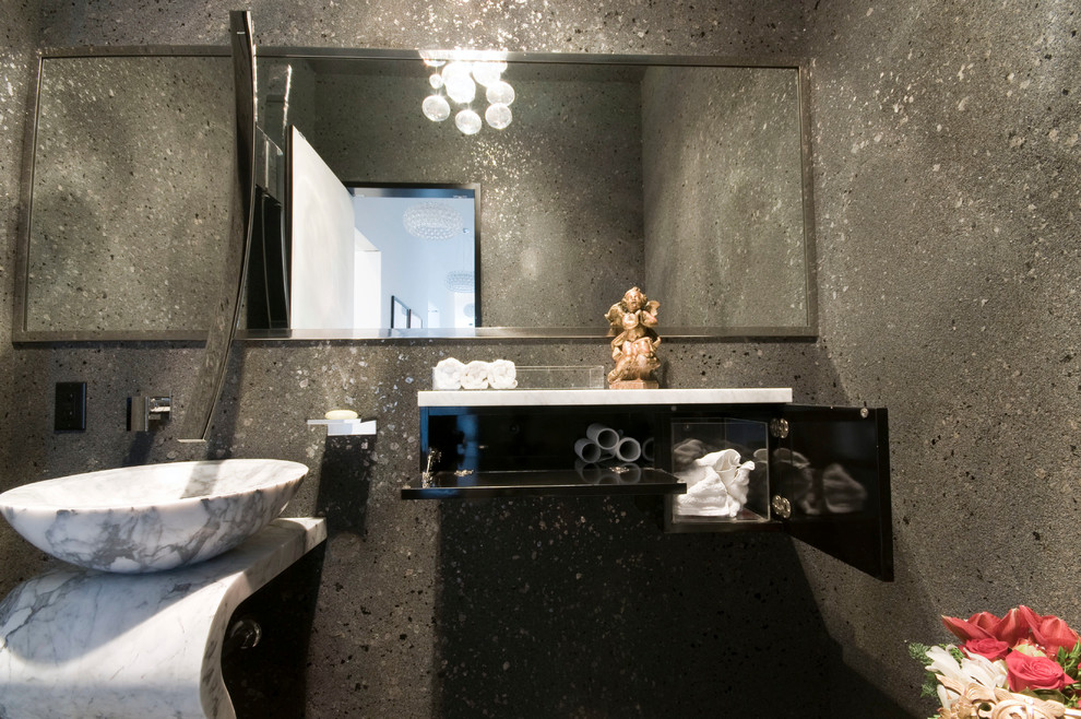 Idee per un piccolo bagno di servizio minimal con lavabo a colonna, ante lisce, ante in legno bruno, WC monopezzo, piastrelle grigie e pareti grigie