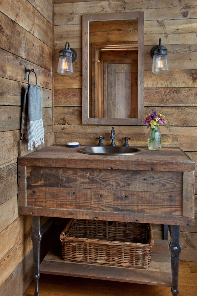 Idee per un bagno di servizio stile rurale con consolle stile comò, ante in legno scuro, lavabo da incasso, top in legno e top marrone