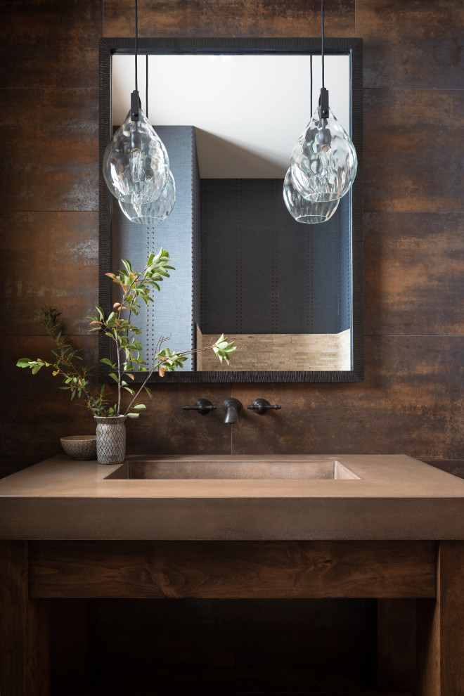 Ejemplo de aseo rústico con puertas de armario de madera en tonos medios, paredes marrones, lavabo integrado y encimeras marrones