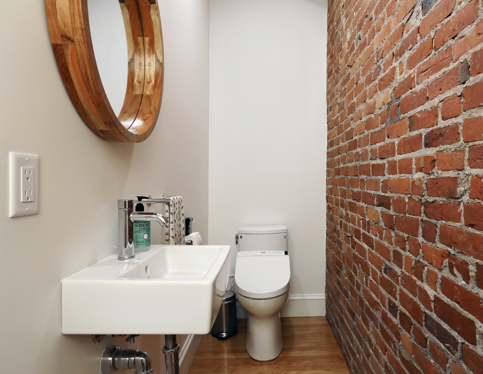 Exemple d'un petit WC et toilettes chic avec un bidet, un mur blanc, un sol en bois brun et un lavabo suspendu.