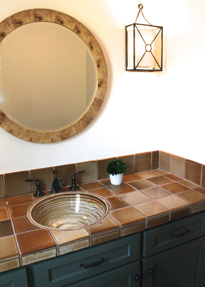 Bild på ett litet eklektiskt toalett, med skåp i shakerstil, gröna skåp, en toalettstol med hel cisternkåpa, flerfärgad kakel, keramikplattor, beige väggar, mörkt trägolv, ett nedsänkt handfat och kaklad bänkskiva