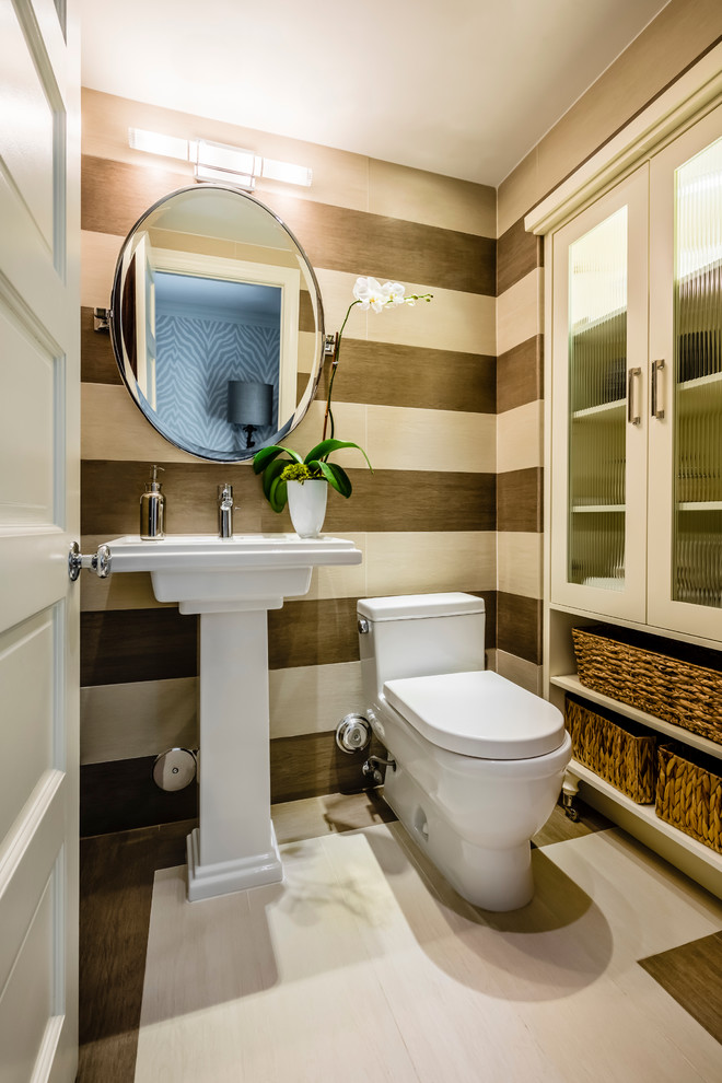 Foto på ett litet funkis toalett, med en toalettstol med hel cisternkåpa, beige väggar och ett piedestal handfat