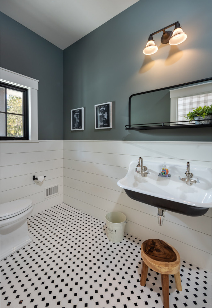 Inredning av ett klassiskt stort toalett, med en toalettstol med separat cisternkåpa, grå väggar, ett väggmonterat handfat och flerfärgat golv
