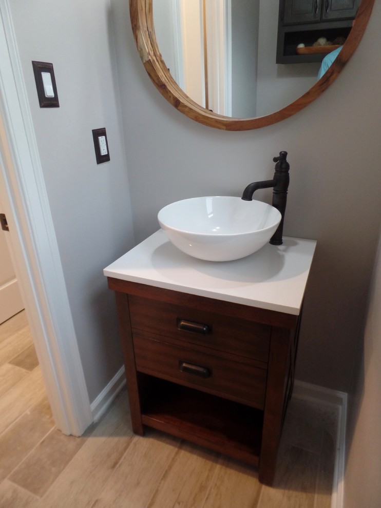 Aménagement d'un petit WC et toilettes classique en bois brun avec un placard en trompe-l'oeil, WC séparés, un mur gris, un sol en carrelage de porcelaine, une vasque, un plan de toilette en quartz modifié et un sol gris.