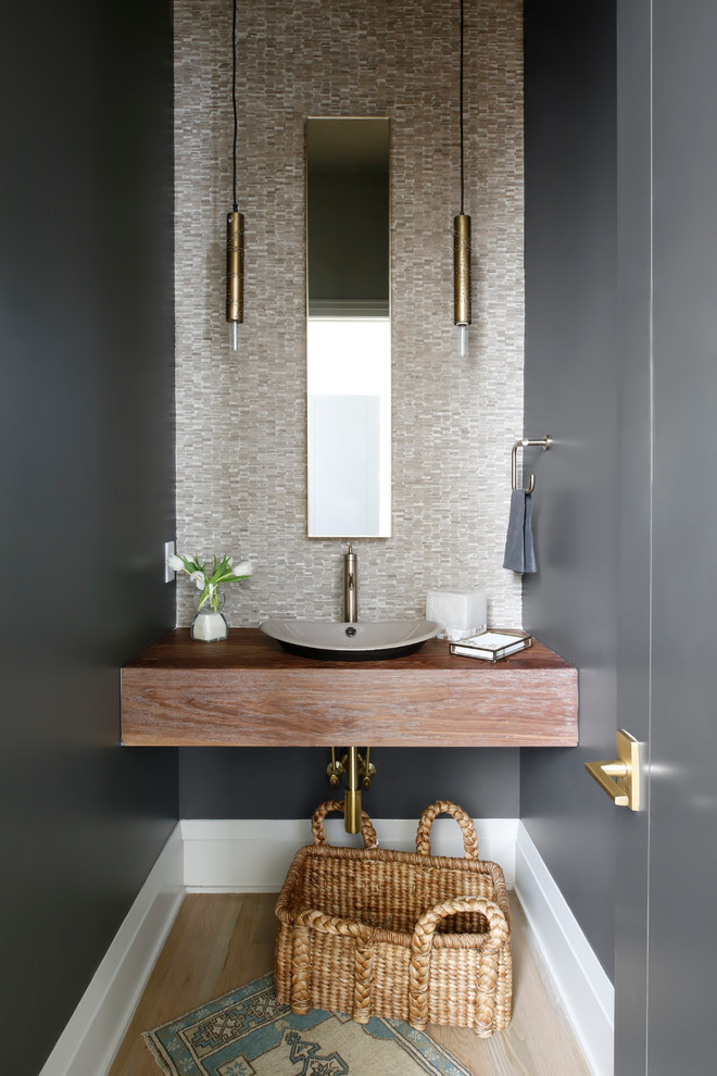 ナッシュビルにあるトランジショナルスタイルのおしゃれなトイレ・洗面所 (ベージュのタイル、黒い壁、淡色無垢フローリング、ベッセル式洗面器) の写真