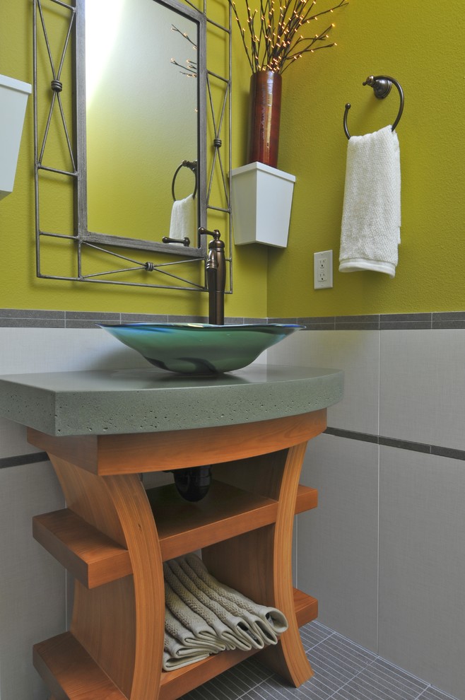 Idee per un bagno di servizio minimal con lavabo a bacinella, top in cemento e top verde