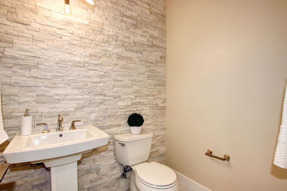 Klassisk inredning av ett mellanstort toalett, med en toalettstol med hel cisternkåpa, beige kakel, skifferkakel, beige väggar, klinkergolv i keramik och ett piedestal handfat
