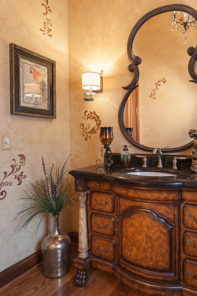 Cette photo montre un WC et toilettes méditerranéen en bois brun de taille moyenne avec un placard en trompe-l'oeil, un plan de toilette en granite, un mur beige et un sol en bois brun.