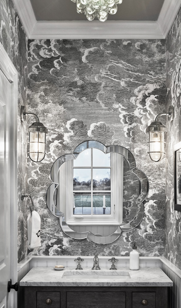 На фото: туалет в стиле неоклассика (современная классика) с плоскими фасадами, серыми фасадами, серой плиткой, серыми стенами, врезной раковиной, белой столешницей, напольной тумбой и обоями на стенах