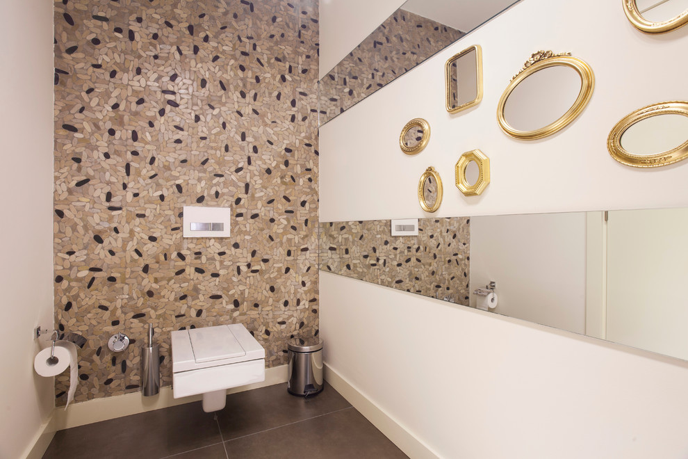 Bild på ett funkis toalett, med en vägghängd toalettstol och beige kakel