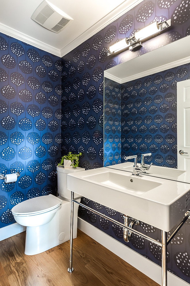 Réalisation d'un WC et toilettes design de taille moyenne avec WC séparés, un mur bleu, un sol en bois brun, un plan vasque, un sol marron et un plan de toilette blanc.