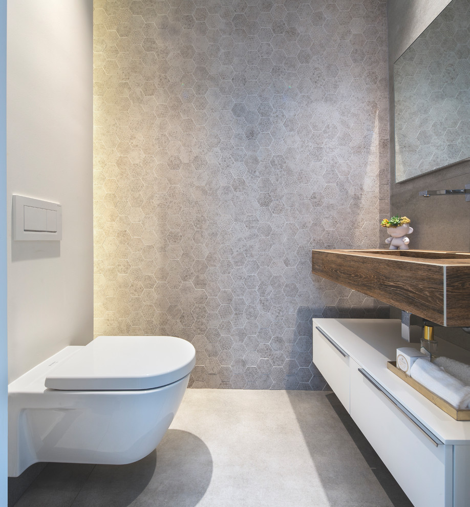 Contemporary cloakroom in Miami with flat-panel cabinets, white cabinets, a wall mounted toilet, grey tiles, mosaic tiles, grey walls, concrete flooring, an integrated sink, grey floors and brown worktops.
