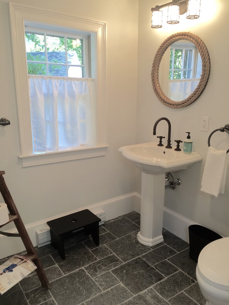 Photo of a medium sized rural cloakroom in Portland Maine with a two-piece toilet, white walls, slate flooring, a pedestal sink and grey floors.