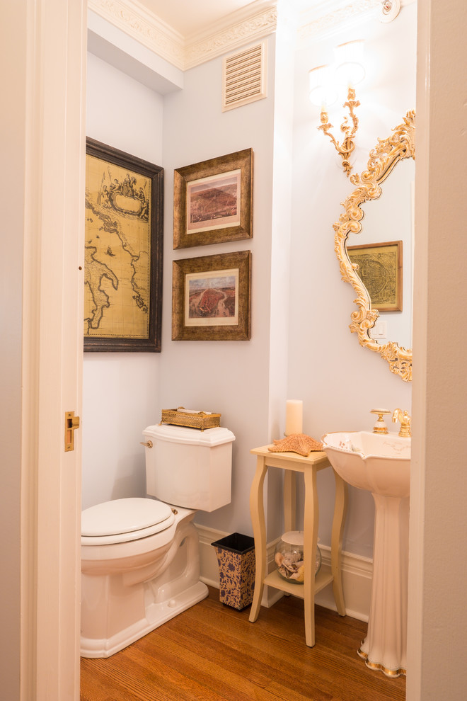 Klassische Gästetoilette mit Wandtoilette mit Spülkasten, blauer Wandfarbe, braunem Holzboden, Sockelwaschbecken und braunem Boden in Vancouver