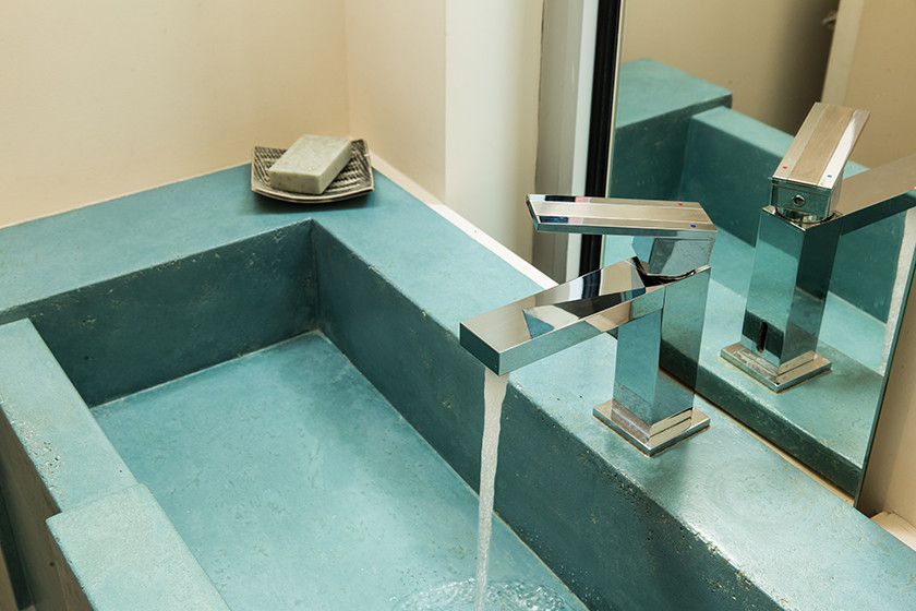 Foto di un bagno di servizio minimalista di medie dimensioni con ante blu, WC monopezzo, pareti bianche, pavimento in gres porcellanato, lavabo integrato, top in cemento, pavimento grigio, top blu e mobile bagno sospeso