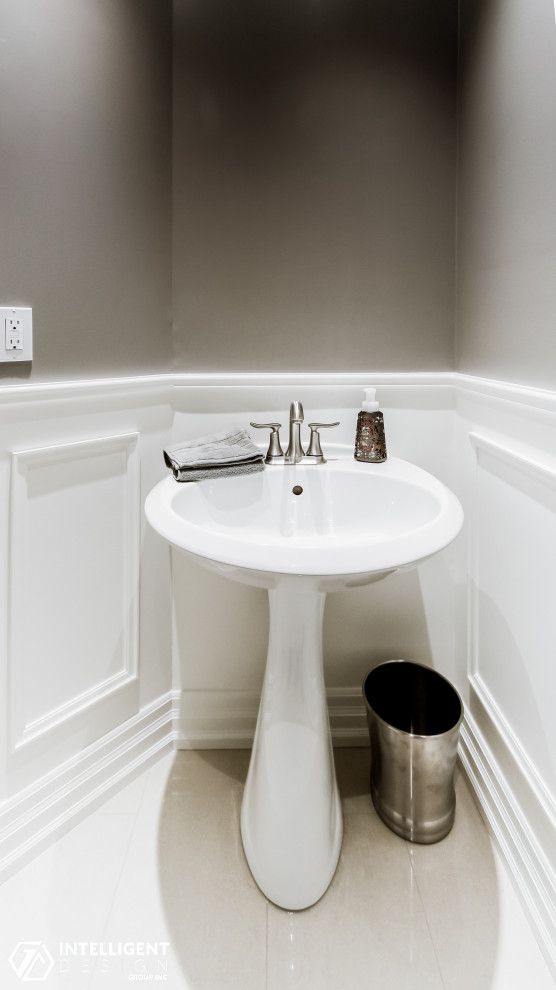 Foto på ett vintage toalett, med en toalettstol med hel cisternkåpa, beige väggar, marmorgolv och ett piedestal handfat