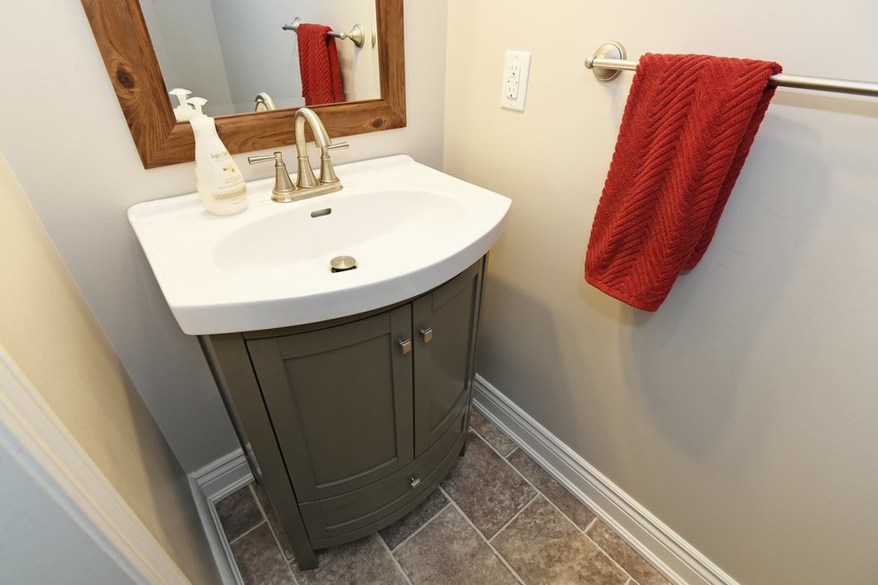 Inspiration for a small craftsman vinyl floor and gray floor powder room remodel in Ottawa with shaker cabinets, gray cabinets, a two-piece toilet, gray walls, an integrated sink and solid surface countertops