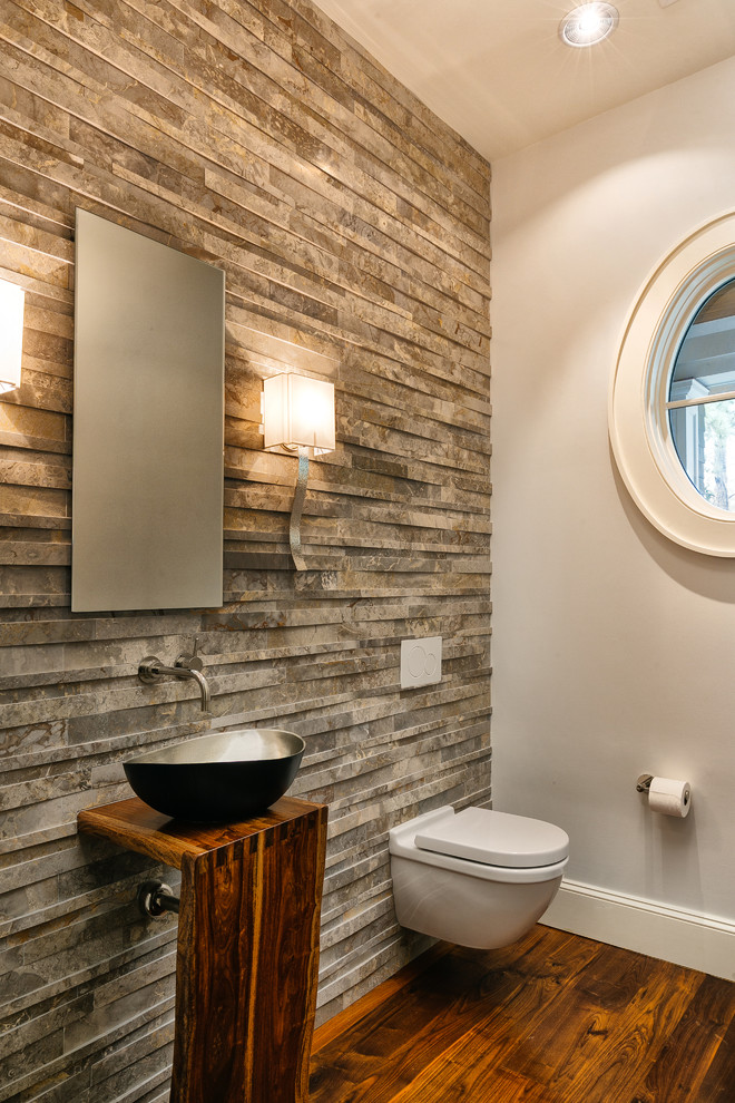 Exemple d'un WC et toilettes craftsman en bois foncé avec un placard sans porte, WC à poser, un carrelage gris, des carreaux de céramique, un mur blanc, parquet foncé, une vasque, un plan de toilette en bois et un sol marron.