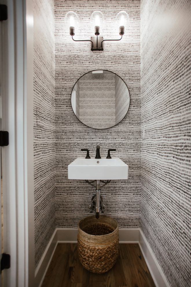 На фото: туалет в стиле кантри с серыми стенами, темным паркетным полом, подвесной раковиной и коричневым полом с