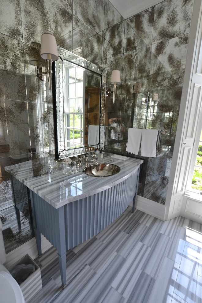 Свежая идея для дизайна: туалет в викторианском стиле с фасадами островного типа, синими фасадами, унитазом-моноблоком, зеркальной плиткой, мраморным полом, накладной раковиной, мраморной столешницей и серым полом - отличное фото интерьера