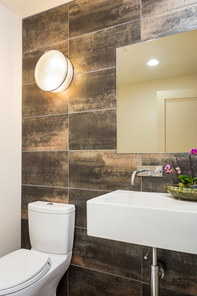 Esempio di un bagno di servizio design con lavabo sospeso, WC a due pezzi e piastrelle marroni