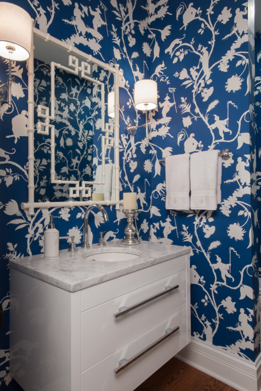 Ejemplo de aseo tradicional renovado pequeño con armarios con paneles lisos, puertas de armario blancas, paredes azules, suelo de madera en tonos medios, lavabo bajoencimera y encimera de mármol