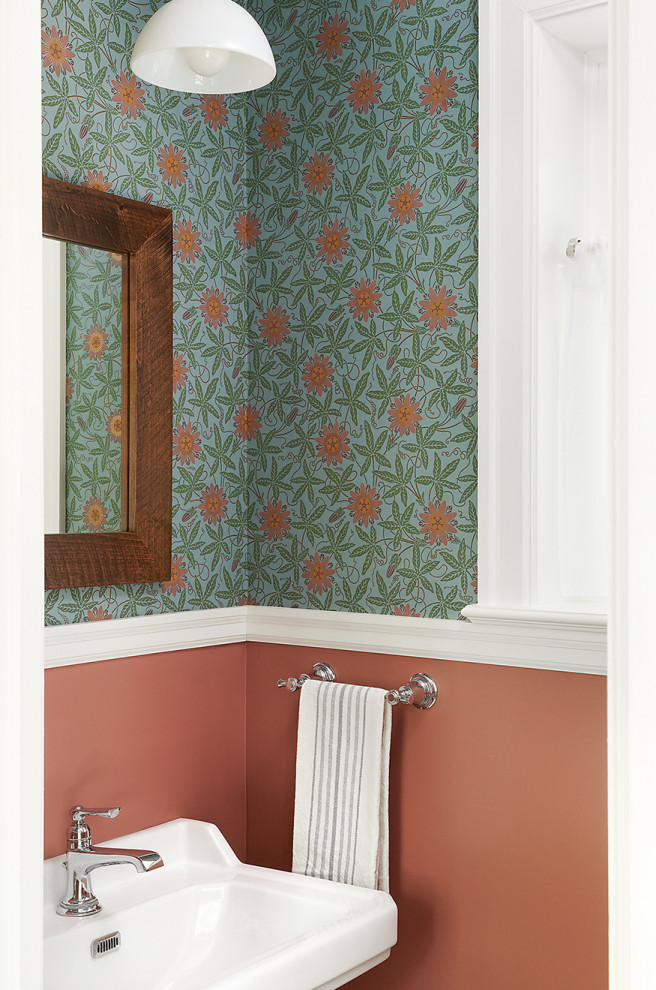 Inredning av ett klassiskt litet toalett, med orange väggar och ett piedestal handfat