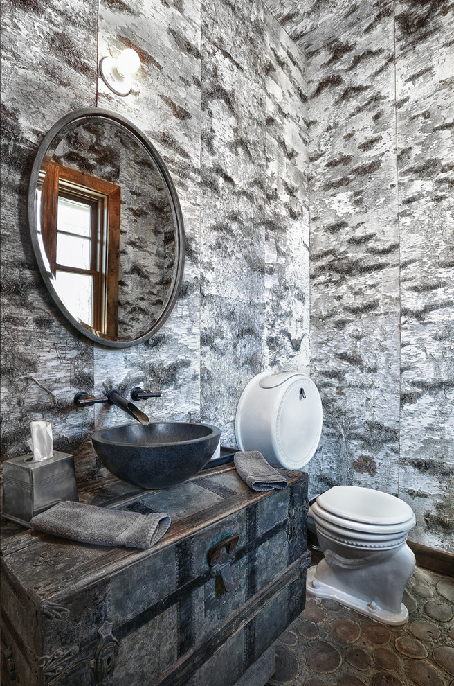 На фото: туалет в стиле рустика с настольной раковиной, фасадами островного типа, унитазом-моноблоком и разноцветными стенами с