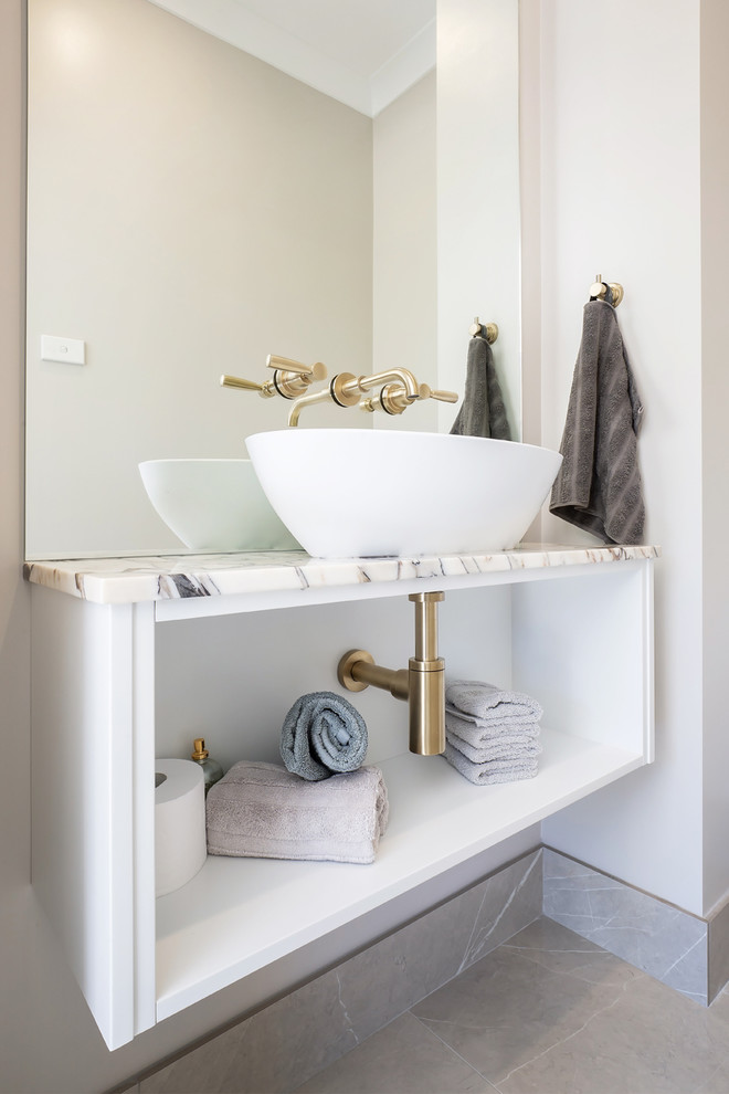 Modern inredning av ett litet beige beige toalett, med öppna hyllor, beige väggar, klinkergolv i porslin, ett fristående handfat, bänkskiva i kvarts och brunt golv