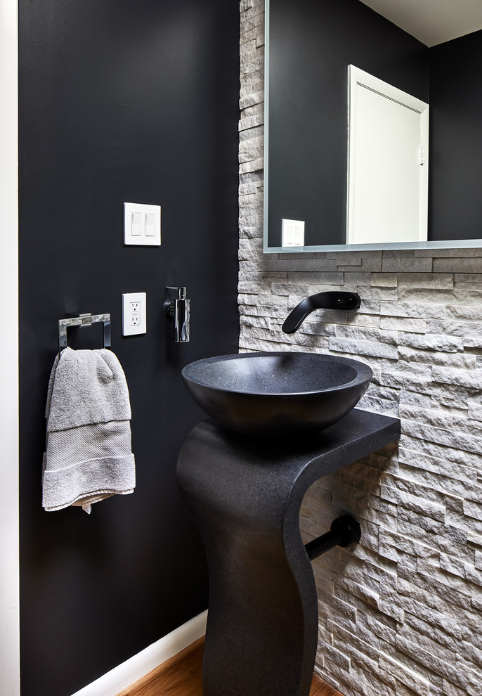 Bild på ett litet funkis toalett, med svarta väggar