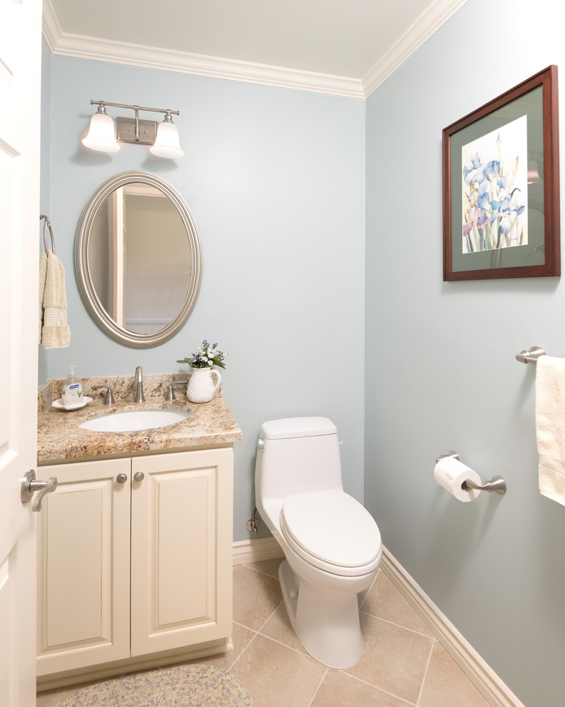 Kleine Landhausstil Gästetoilette mit Toilette mit Aufsatzspülkasten, beigen Fliesen, blauer Wandfarbe, Keramikboden, Unterbauwaschbecken, Granit-Waschbecken/Waschtisch, beigen Schränken und profilierten Schrankfronten in San Diego