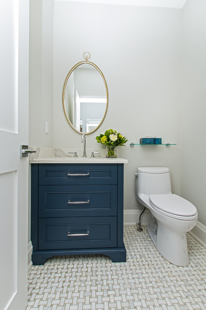 Example of a mid-sized classic marble floor and gray floor powder room design in Toronto with recessed-panel cabinets, blue cabinets, a one-piece toilet, gray walls, an undermount sink, marble countertops and white countertops