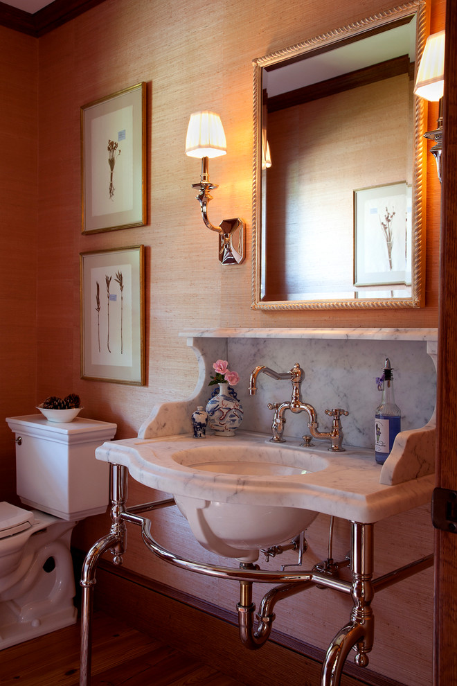 На фото: туалет среднего размера в классическом стиле с раздельным унитазом, паркетным полом среднего тона, раковиной с пьедесталом и мраморной столешницей с