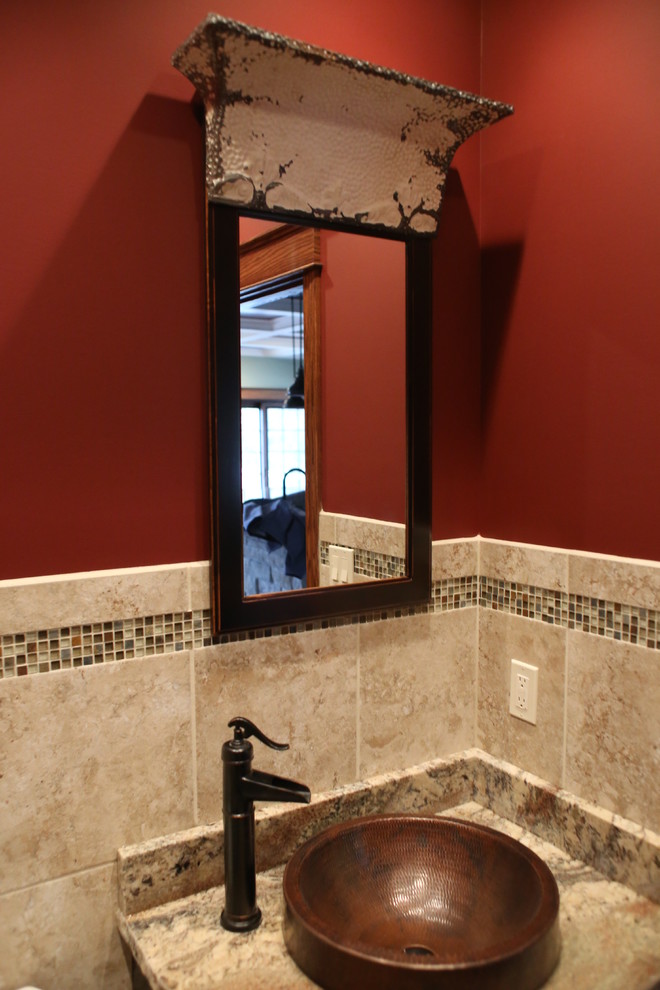 Aménagement d'un petit WC et toilettes montagne en bois foncé avec un mur rouge, WC à poser, mosaïque, une vasque et un plan de toilette en granite.