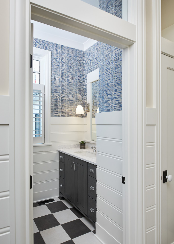 Inredning av ett lantligt toalett, med luckor med infälld panel, svarta skåp, blå väggar, mosaikgolv, ett undermonterad handfat, bänkskiva i kvarts och svart golv