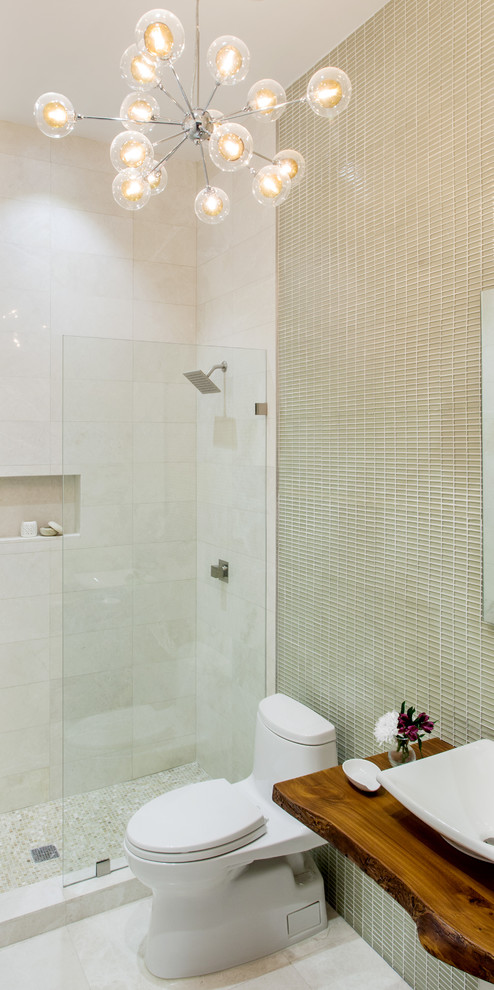 Immagine di un bagno di servizio minimal di medie dimensioni con ante in legno scuro, piastrelle beige, piastrelle di vetro, lavabo a bacinella, top in legno, WC monopezzo e top marrone