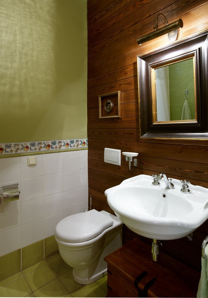 Cette image montre un WC et toilettes rustique de taille moyenne avec un sol en carrelage de céramique, un carrelage blanc, un carrelage vert, des carreaux de céramique, un mur vert, un lavabo suspendu et WC à poser.
