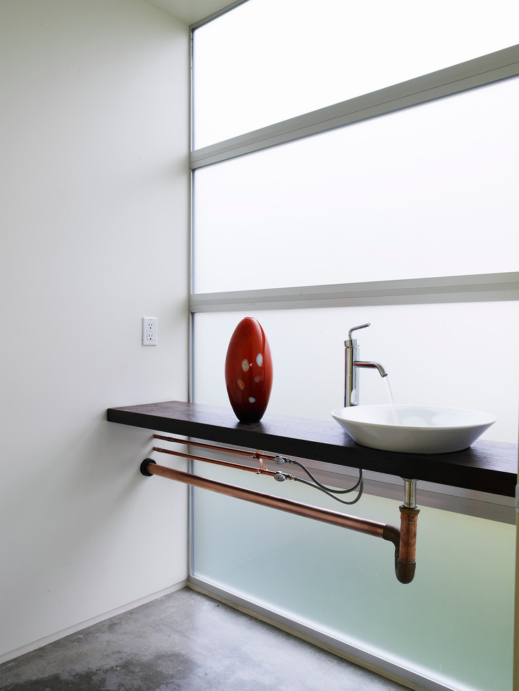 Industrial Gästetoilette mit Aufsatzwaschbecken, weißer Wandfarbe und Betonboden in Seattle