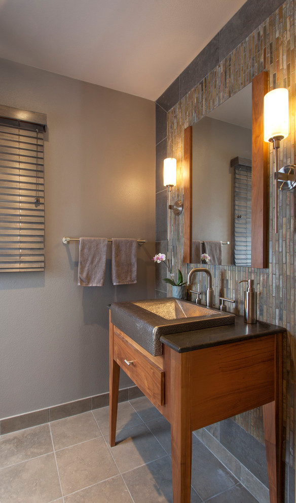 Exempel på ett mellanstort rustikt toalett, med möbel-liknande, skåp i mellenmörkt trä, grå kakel, grå väggar, kalkstensgolv, skifferkakel, ett avlångt handfat, marmorbänkskiva och beiget golv