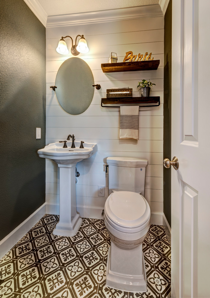 Example of a small farmhouse porcelain tile and black floor powder room design in San Francisco with a two-piece toilet, gray walls and a pedestal sink