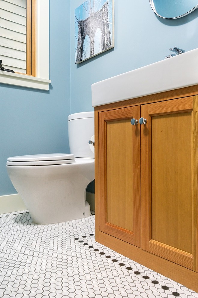 Exemple d'un WC et toilettes chic en bois brun de taille moyenne avec un placard à porte shaker, un mur bleu, un sol en carrelage de terre cuite, une grande vasque, un plan de toilette en surface solide, un sol blanc, WC séparés, un carrelage blanc et des carreaux de porcelaine.